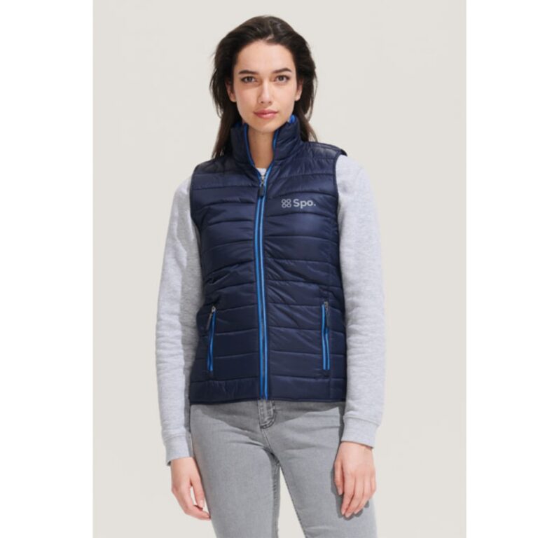 Bodywarmer with logo Wave woman Bodywarmer with logo in lightweight material. This is the sleeveless version of the popular Ride jacket but offers greater freedom of movement. Can also be used as an extra layer under a jacket. Wind and water repellent material, 2 pockets with stylish zippers and colour matched lining, high collar, stylish fit. Tone-on-tone reinforcement at the hem. Fabric details: 100% nylon. Depending on the surface we can use embroidery, engraving, 360° imprint or screen print.